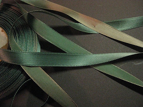 Teal satin rayon ribbon is faded